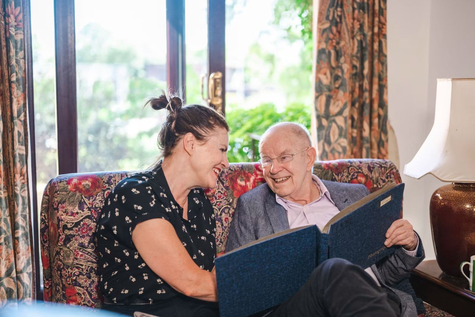 A care professional assisting an older adult during a routine visit